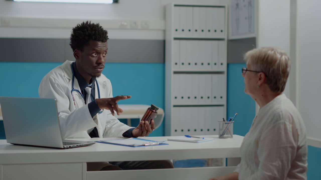 Young man working as medic holding bottle of pills