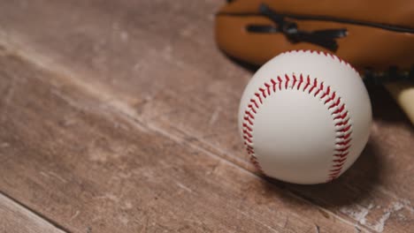 close up studio baseball still life with ball in catchers mitt on wooden floor