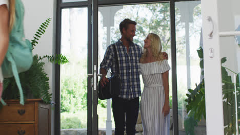 una pareja feliz llegando a casa con su hija.