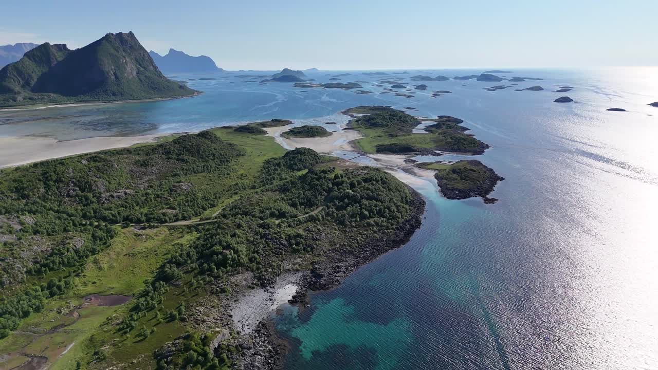 Stunning high-altitude drone view of Engeløya island in northern Norway, with sharp mountain peaks, sandy beaches, small islets, and deep blue sea