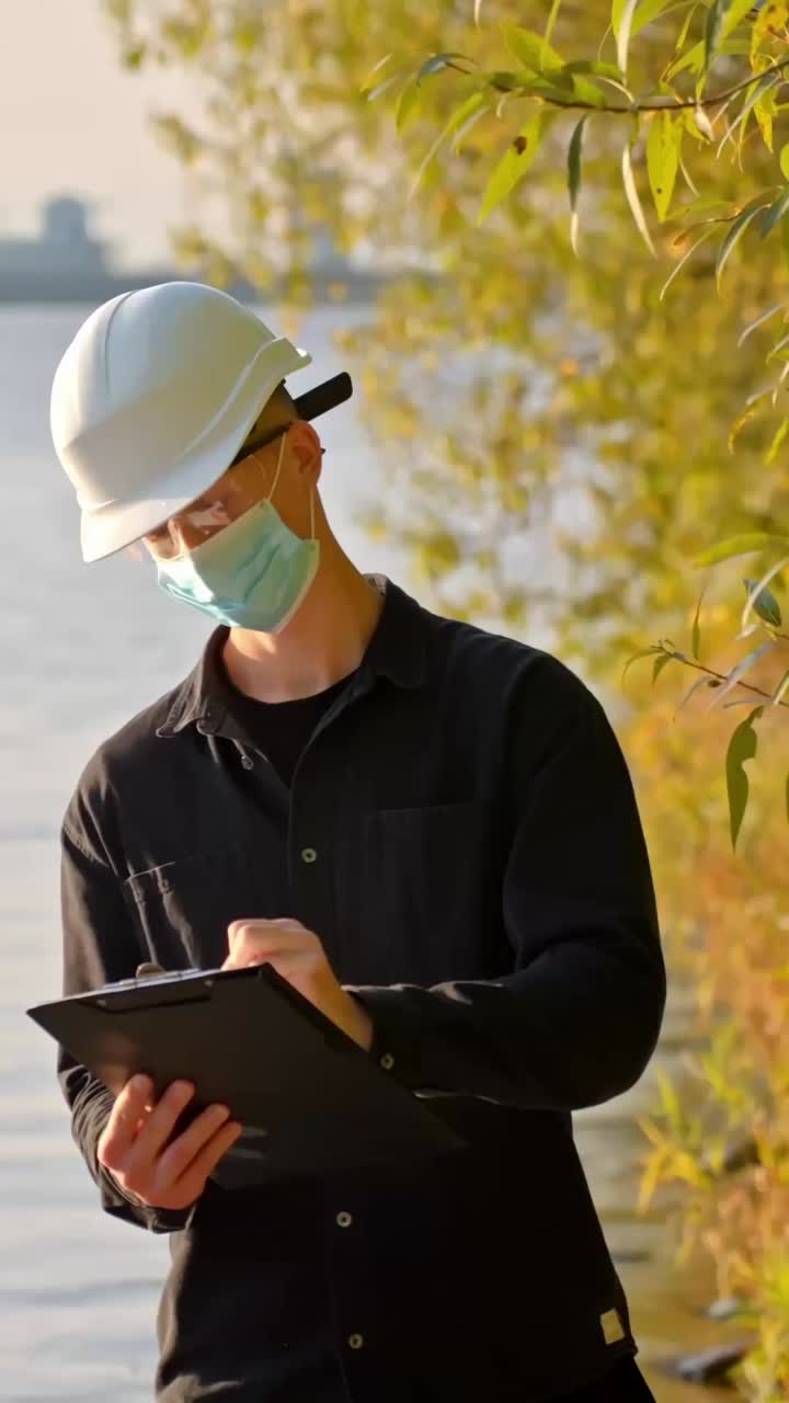 Environmental engineer documenting data from a water quality test, vertical
