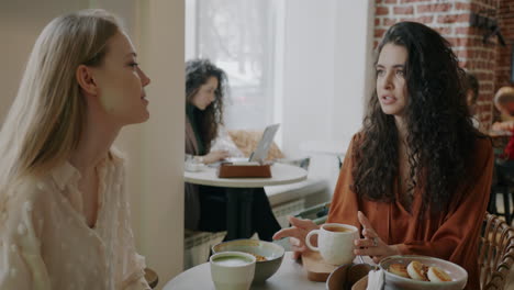dos mujeres teniendo una conversación en un café