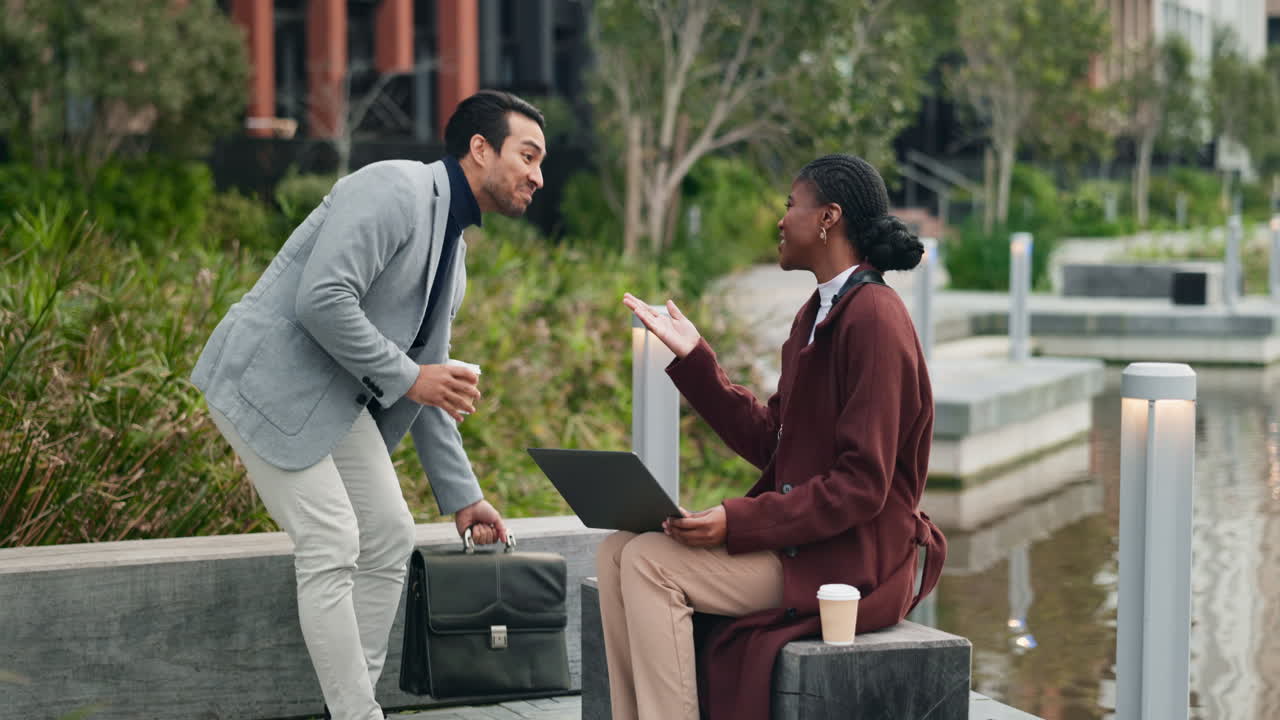 Two businesspeople shaking hands in a city park