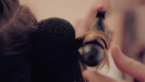 el estilista está haciendo un peinado para una chica joven
