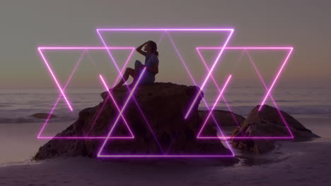 Person sitting on rock by ocean with glowing purple triangle animation overlay