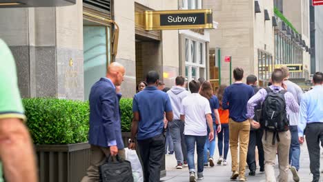 pedestrians passing a subway entrance