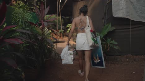 Girl-walking-away-with-handbags-and-a-painting-in-hand