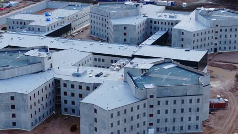 Aerial view of a large prison under construction, showing modern security design