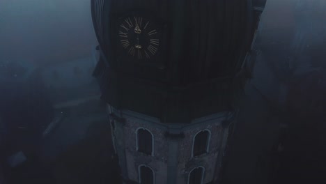 scary aerial drone view through clouds on church in old town riga, latvia, europe