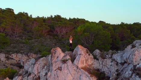 smooth aerial top view flight ibiza cliff yoga tree pose model girl sunset evening