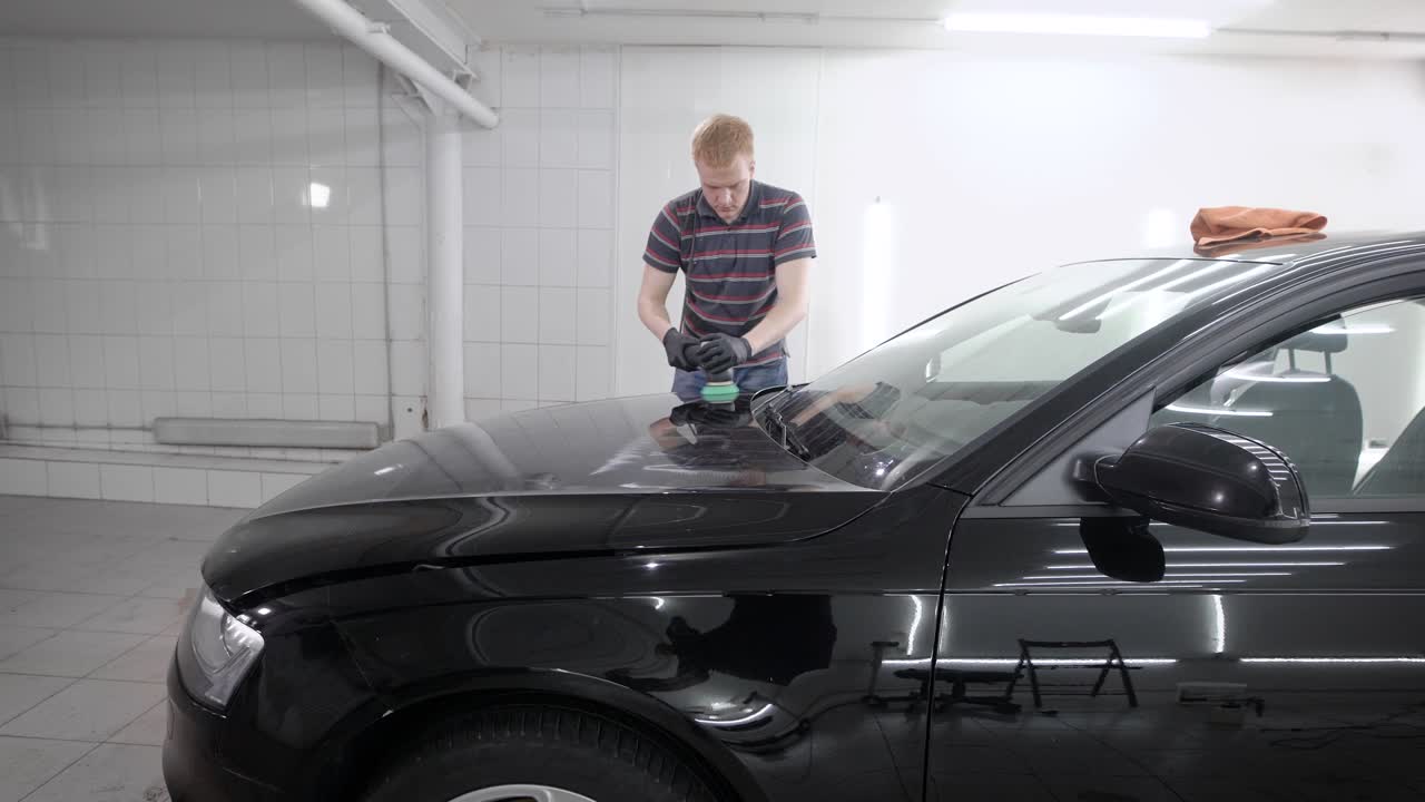 trabajador moliendo coche en el garaje