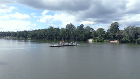 Drone shot tracking around the Sackville Ferry as it heads across the Hawkesbury river laden with cars, Australia