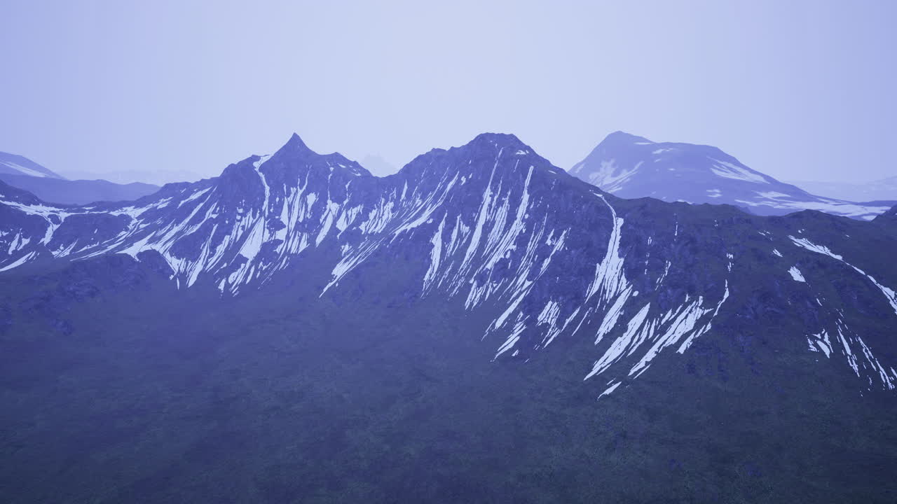 Snow capped mountain peaks with dramatic ridges during twilight hours