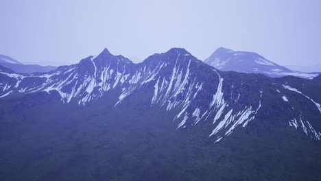snow capped mountain peaks with dramatic ridges during twilight hours