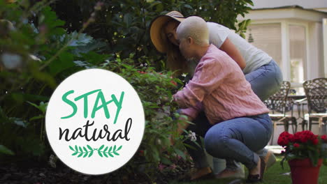 animation of stay natural text over gay lesbian couple gardening together in garden