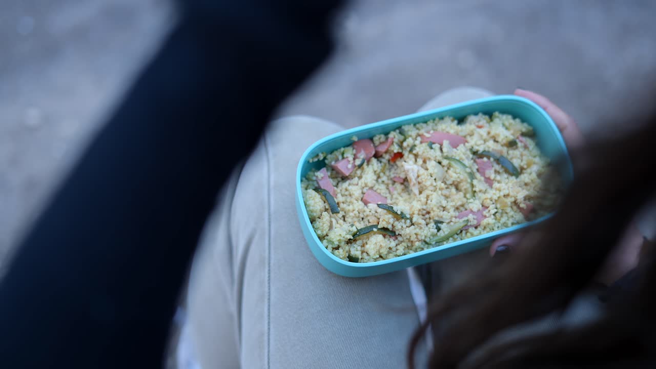 Woman eating lunch from a lunchbox