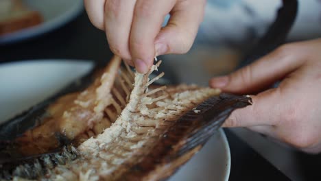 El-Cliente-Del-Restaurante-Quita-El-Hueso-Del-Pescado-A-La-Parrilla,-Cierra-La-Cámara-Lenta