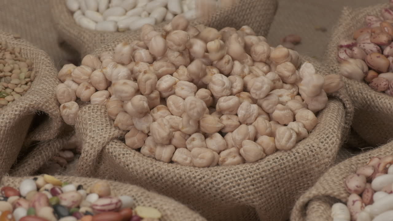 Ceci secchi crudi, legumi vegani e vegetariani che cadono in una ciotola di juta