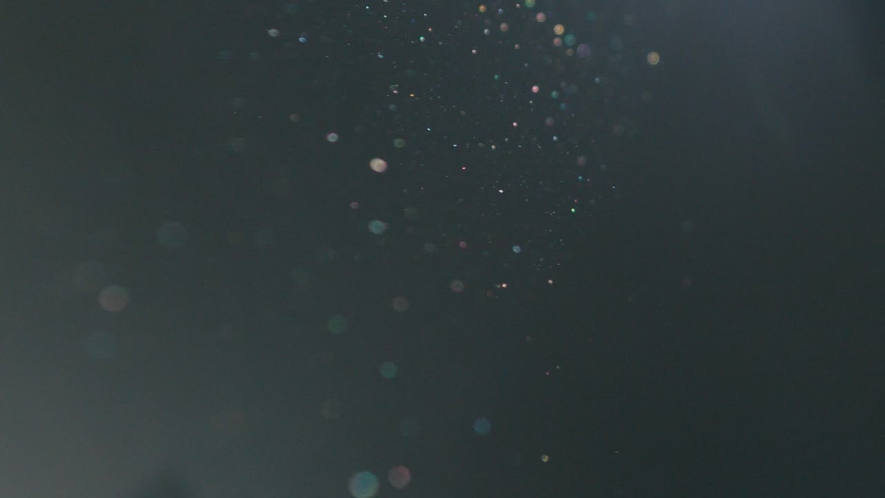 먼지는 어두운 방에서 느린 동작으로 떠다닙니다.