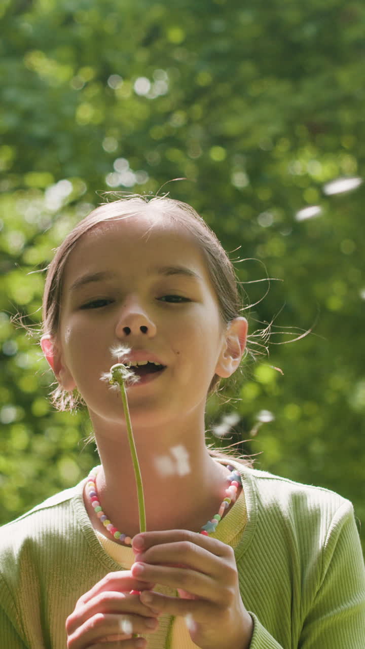 chica soplando semillas de diente de león