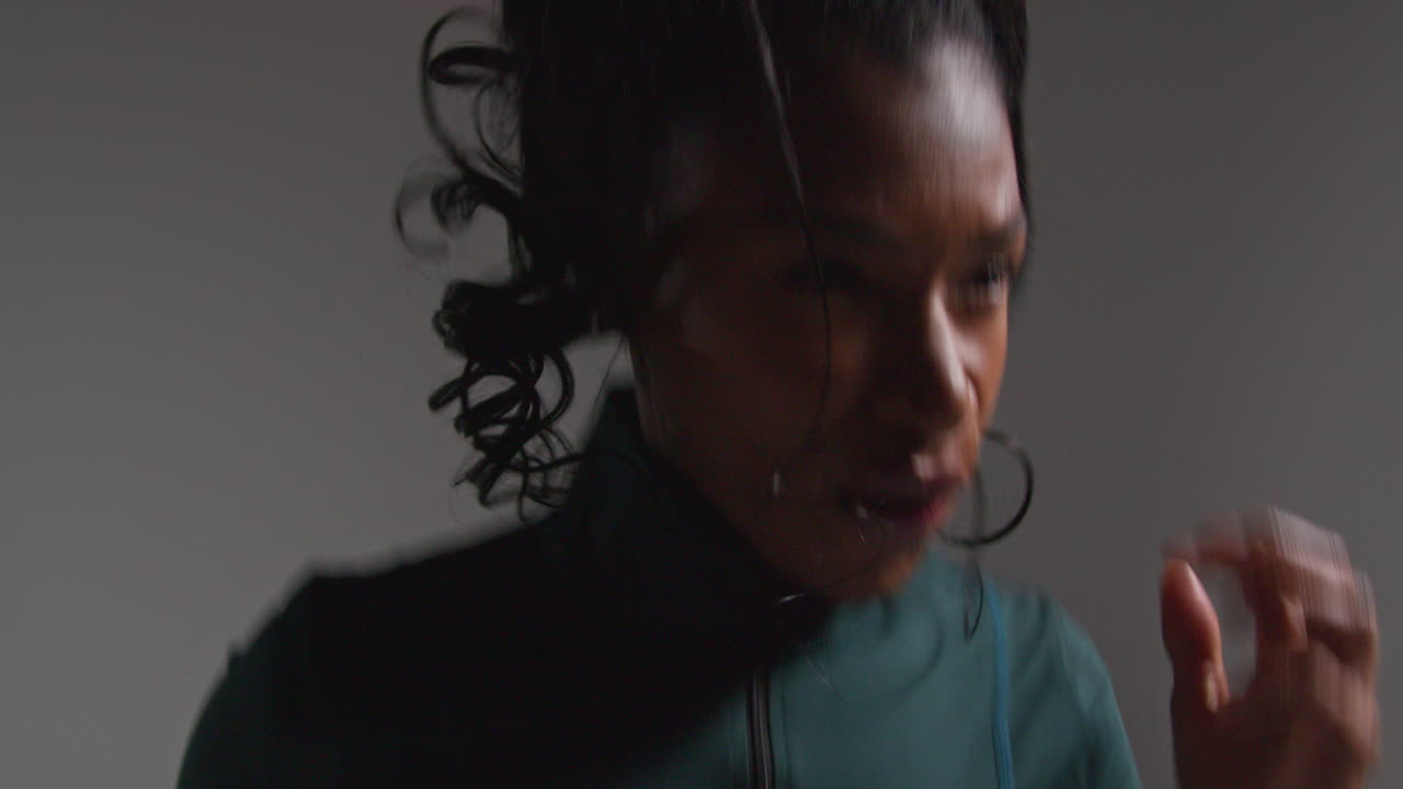 fotografía de estudio de cerca de una atleta que lleva un traje de entrenamiento sin aliento con expresión de dolor y recuperación después del ejercicio