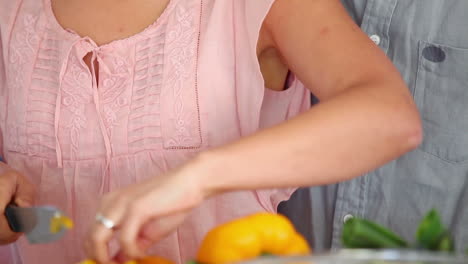 Mujer-Alimentando-A-Un-Hombre-Con-Pimientos-Después-De-Cortarlos.