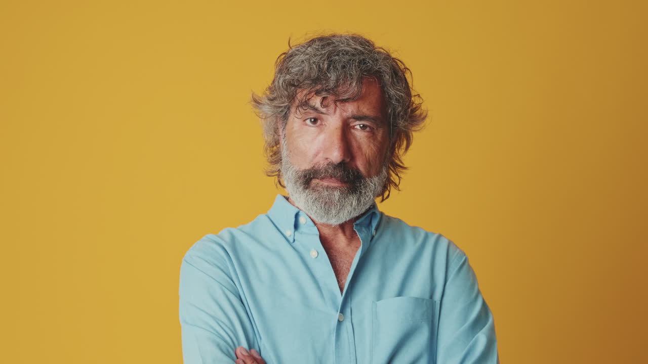 Serious Middle-Aged Man Looking at Camera with Crossed Arms