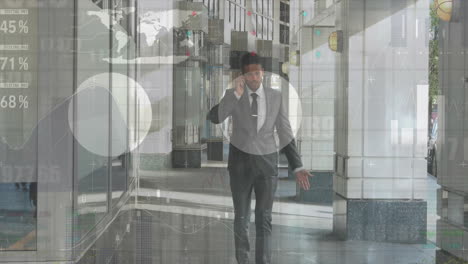 animation of graphs and charts over caucasian businessman talking on smartphone and walking