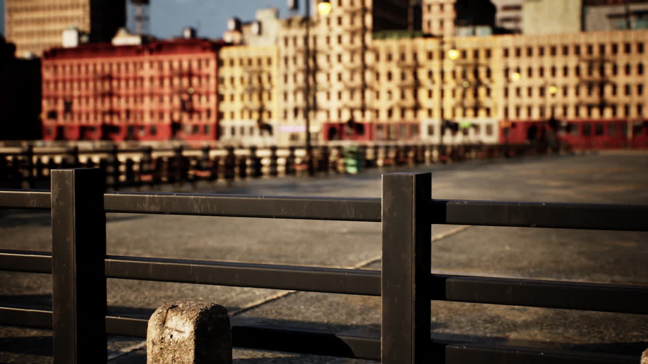 A view of a city street with a fence in the foreground