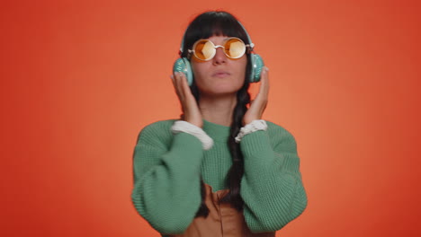 Young-happy-woman-in-headphones-listening-music-and-dancing-disco-having-fun-relaxing-on-party