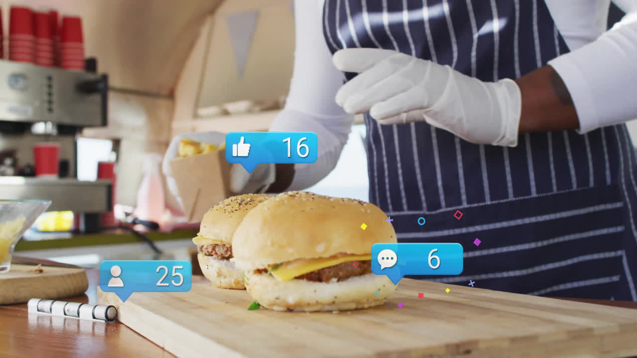 Male vendor preparing burgers inside food truck, showing floating social media reaction overlays