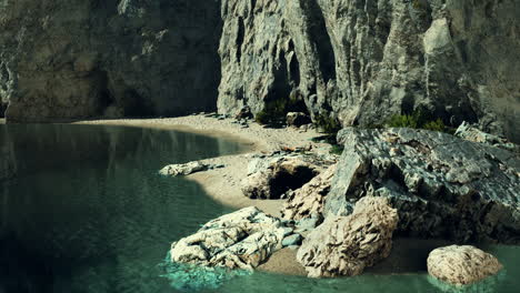 small sand ocean beach near rocky cliff