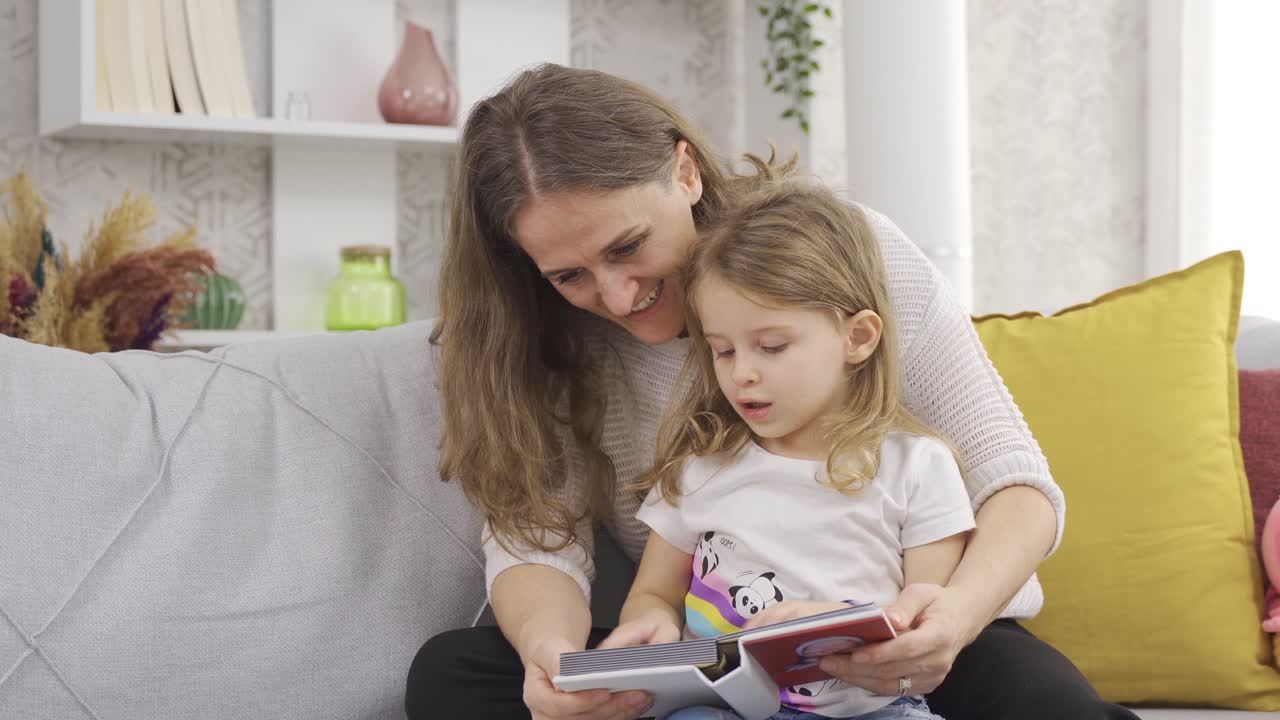 la madre y la niña miran el álbum de fotos. madre e hija sorprendidas.