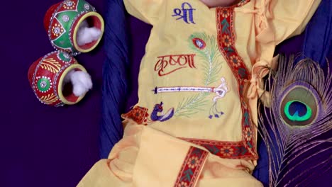 niño recién nacido en Krishna vestido con accesorios desde una perspectiva única en una expresión diferente