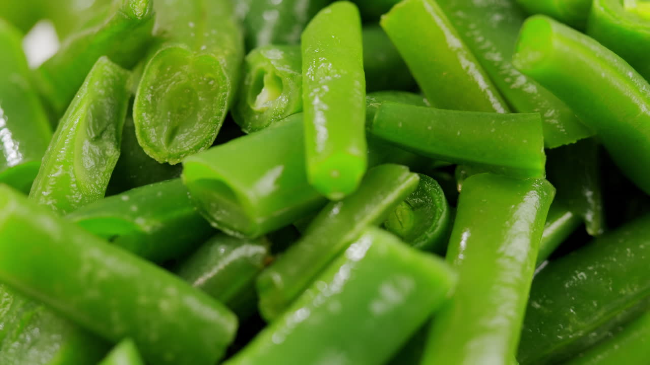 Raw frozen beans for Fried wok, green beans with onions and spices in a white plate on a gray background. Flat lay. Top view