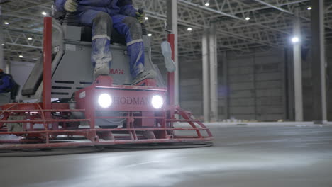 worker operating a floor screed machine