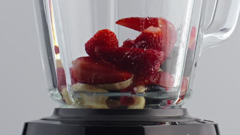 blender filling fruits berries in super slow motion closeup. natural ingredients