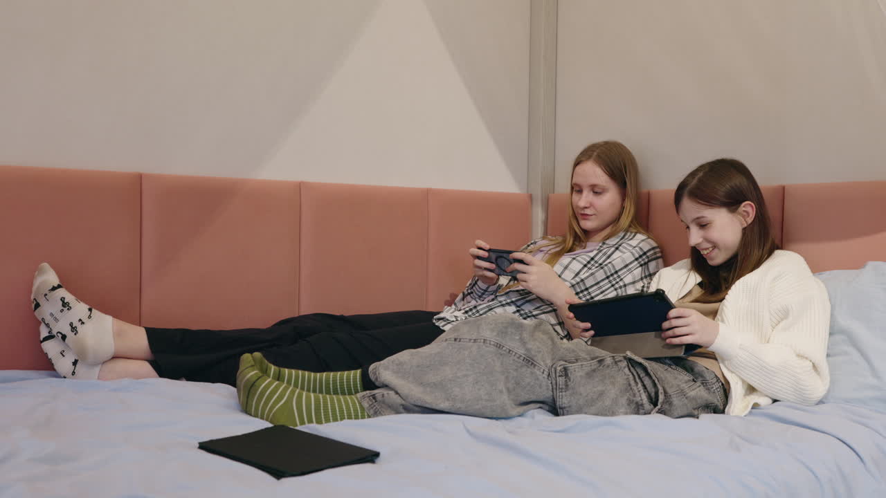 Teenage girls gaming in bed