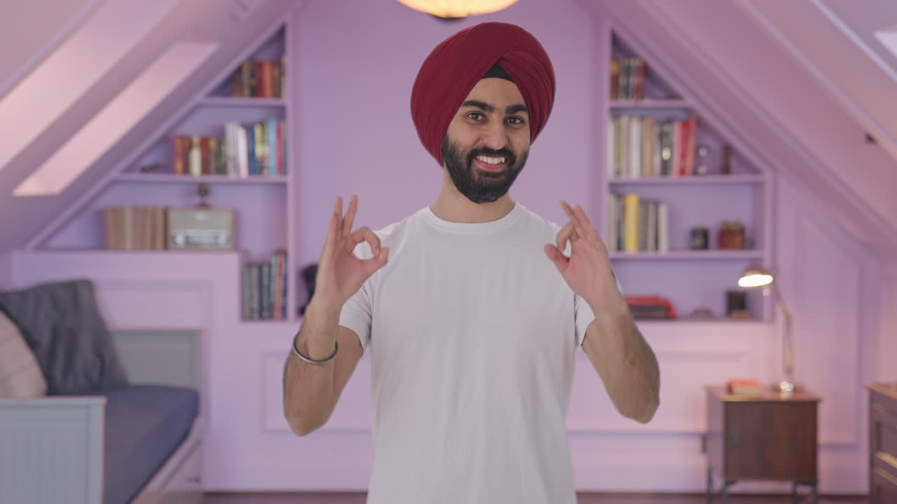 Uomo indiano Sikh felice che fa il segno dell'ok