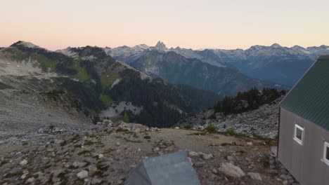 Cabaña-Solitaria-En-El-Pico-De-La-Montaña-Al-Atardecer-Con-Revelación-Del-Paisaje-Montañoso-Con-Un-Hermoso-Horizonte-De-Hora-Dorada-En-El-Monte-Brew-Canadá-4k