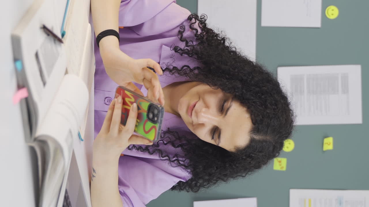 video vertical de una estudiante adicta al teléfono.