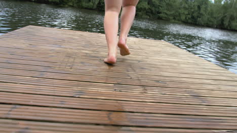 Person running on a dock by a lake