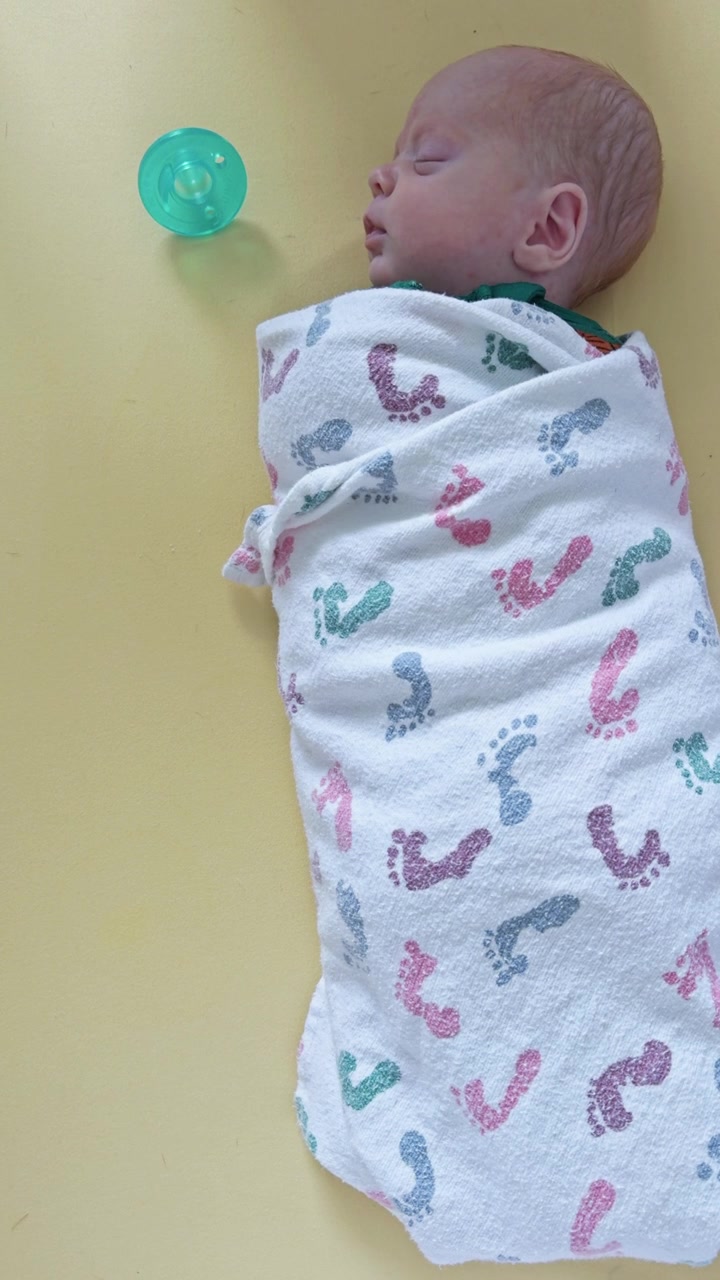 Un bambino dorme pacificamente nella sua culla con il ciuccio accanto alla sua testa che riposa