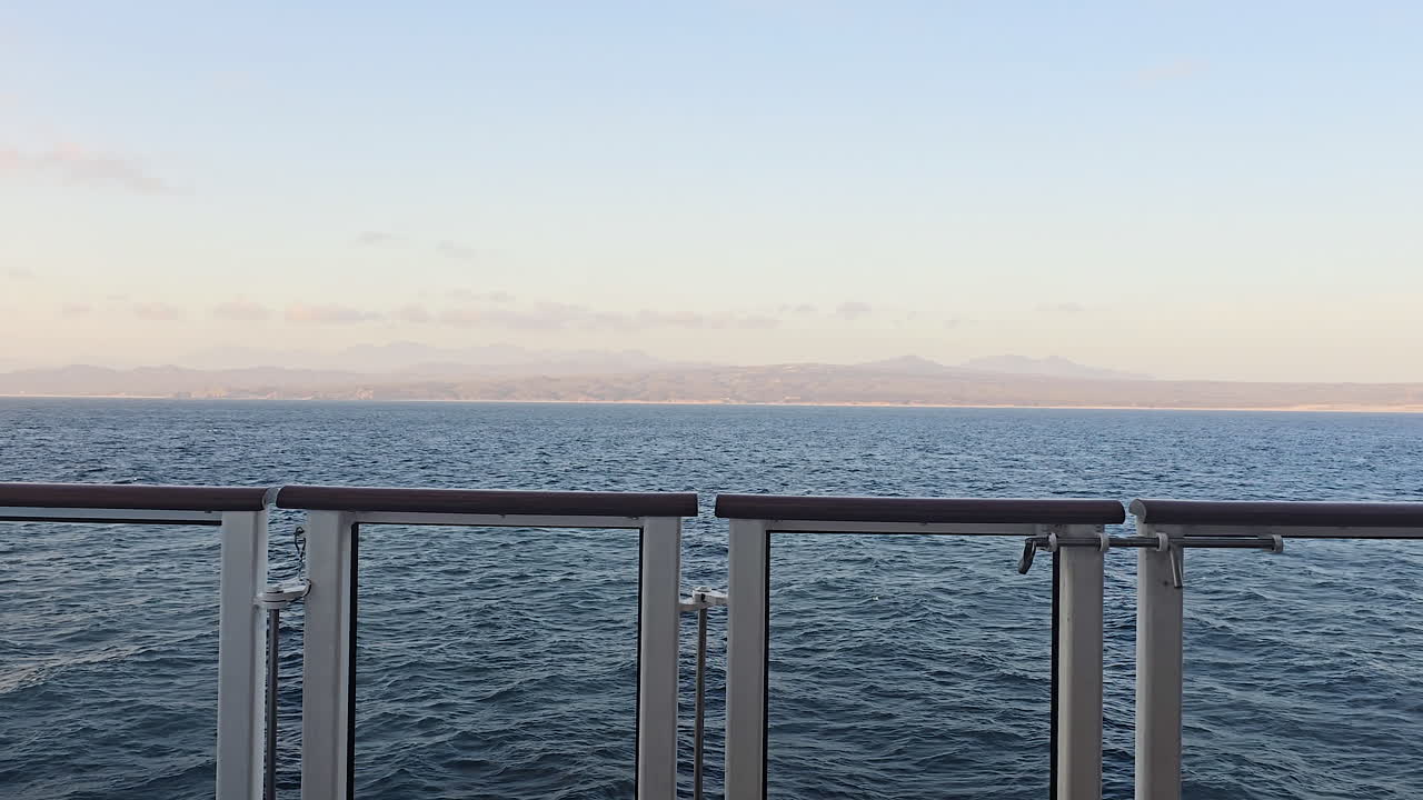 Küstenlinie von Cabo San Lucas vom Balkon eines Kreuzfahrtschiffs aus, während man das tiefblaue Wasser des Ozeans genießt, entlang Baja California Sur segelt und eine entspannende Seereise erlebt.