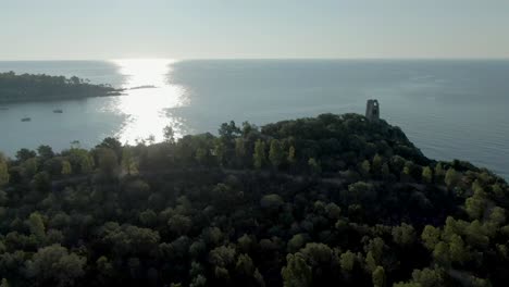 Aerial-view-of-San-gemiliano-tower-on-the-top-of-rock-bound-formation-cliff-in-east-coastline-of-Sardinia,-Italy