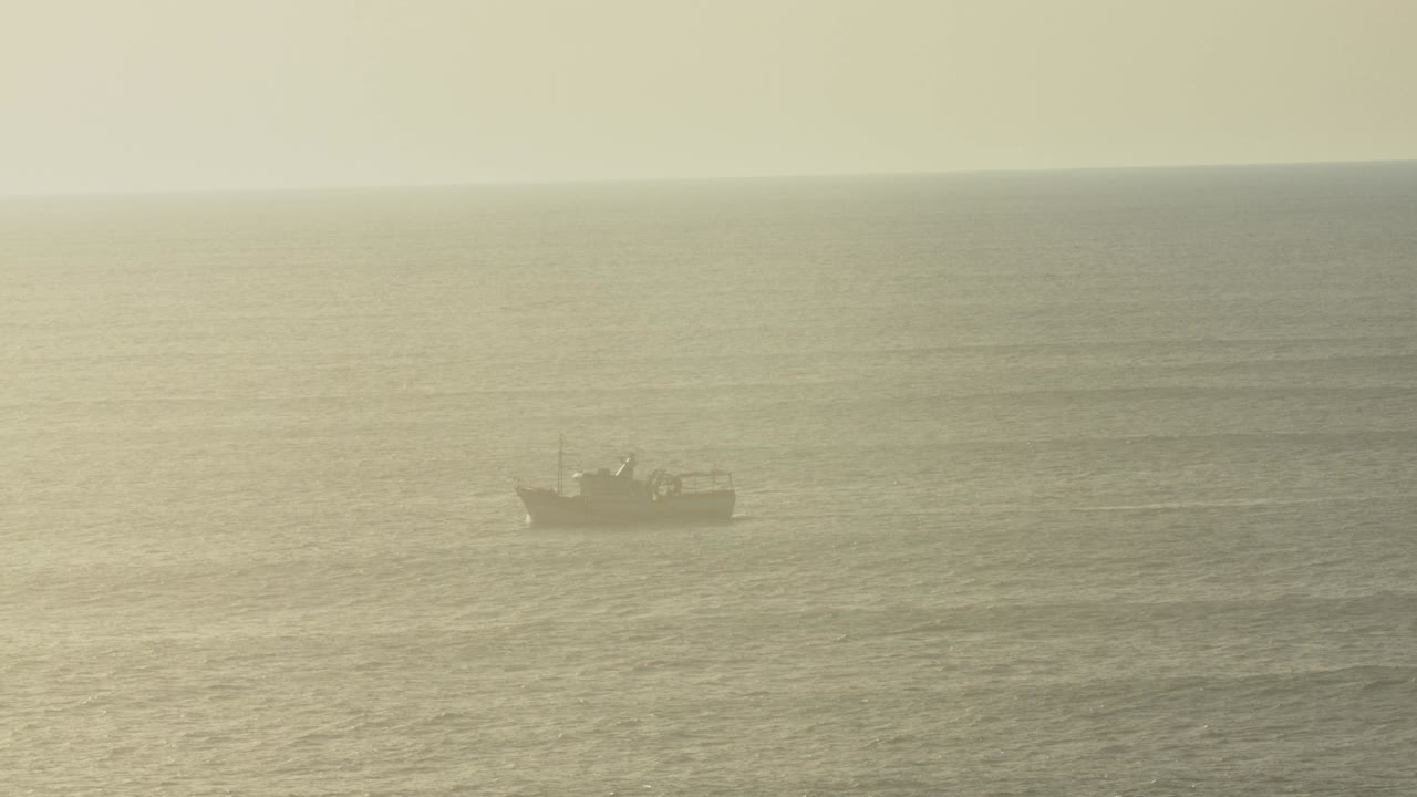 석양에 포르투갈의 해안선을 따라 순항하는 보트