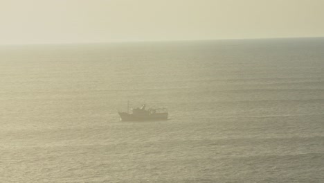 Boat-cruising-along-the-coastline-of-Portugal-at-sunset