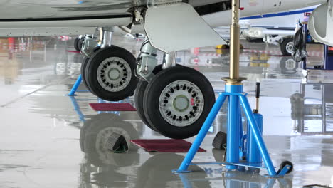 biz jet aircraft on jacks during maintenance, zoom in on undercarriage