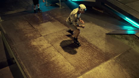 Young-teens-practicing-together-on-roller-skates-and-skate-board-at-skate-park.