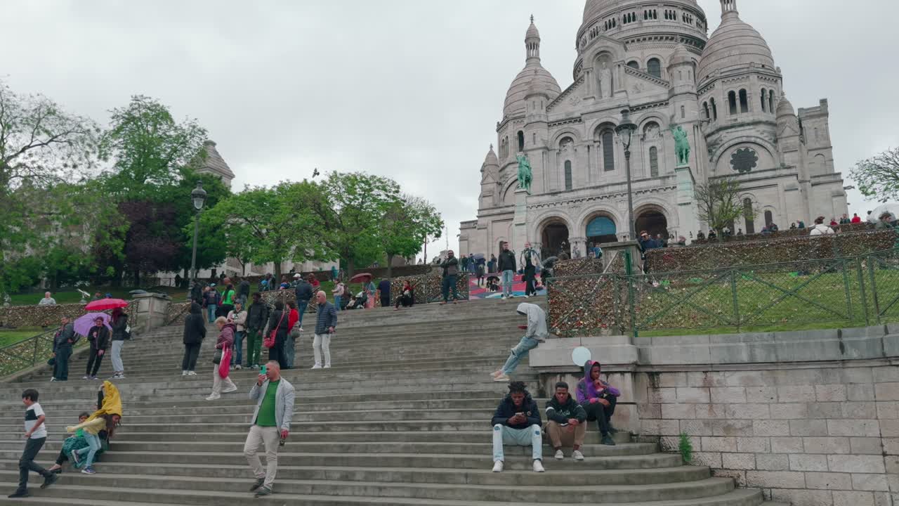 People At The Staircase Of The Basilica Of Sacré Cœur de Montmartre In Paris, France. Tilt-up Shot